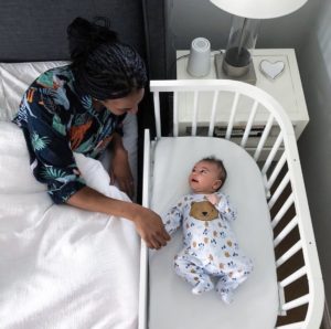 Mother comforting baby who is crying during sleep | babybay cosleeper cribs