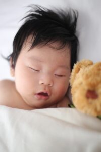 A baby sleeping peacefully after their parents have figured out how to deal with sleep deprivation as a parent | babybay co-sleepers