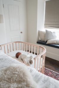 An infant resting in a bedside co sleeper | babybay Bedside Bassinet 