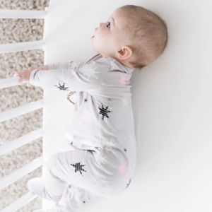 A baby sleeping with cotton sheets for crib | babybay bedside co-sleeper