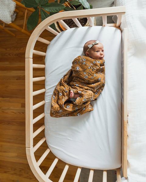 An infant co-sleeping in a bedside co-sleeper | babybay Bedside Bassinet 