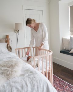 Mother looking at daughter in safe co-sleeping co-sleeper | babybay bedside cribs