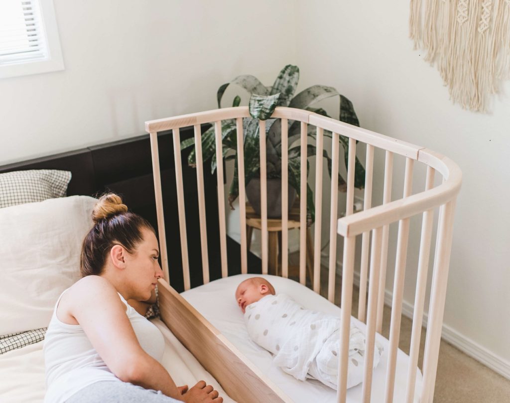 A mother watching a baby safely co-sleep | babybay Bedside Co-sleepers
