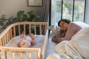 Mother and child safely co-sleeping with a bedside bassinet | babybay co-sleepers