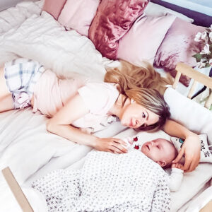 Woman snuggling baby before transitioning from co-sleeper to crib | babybay bedside co-sleepers 