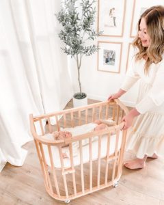 Mother pulling baby in a co-sleeper crib | babybay Bedside Sleepers