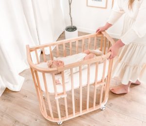 Mother rolling wooden bassinet with wheels | babybay Bedside Bassinets