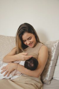 Mother breastfeeding a newborn | babybay bedside bassinets