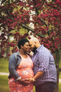 Man and pregnant woman standing under tree while waiting for newborn baby | babybay bedside sleepers