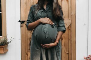 Pregnant woman feeling rested after sleeping with a pregnancy pillow | babybay cosleeper cribs