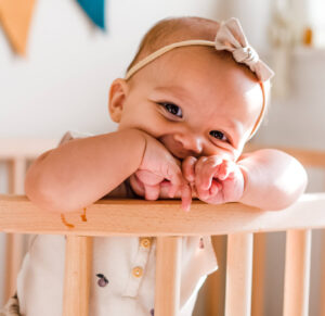 Baby smiling while safely co-sleeping in bedside sleeper | babybay bedside co-sleepers
